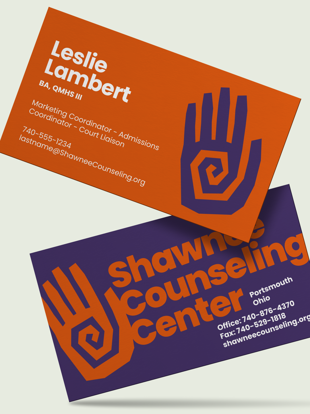 Orange and purple Shawnee Counseling Center business cards with the spiral hand symbol.